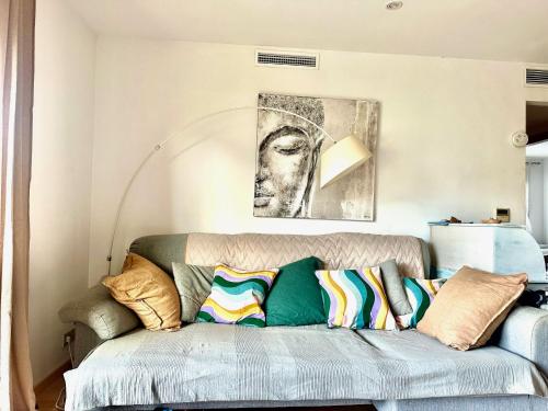 a living room with a couch with colorful pillows at Puerto Pollensa peaceful apartment, mountain views in Port de Pollensa