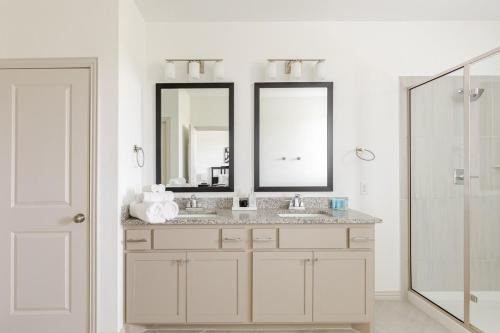 a bathroom with two sinks and a mirror at Stylish Living in Vibrant Frisco in Frisco