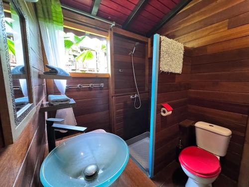 bagno con servizi igienici rossi e lavandino di Bungalow créole en pleine nature a Petit-Bourg