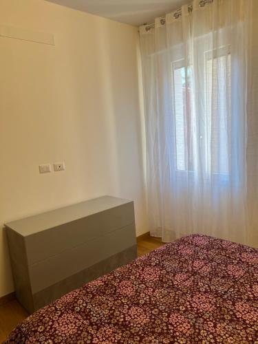 a bedroom with a bed and a dresser and a window at Appartamento Liguria5 in Bologna