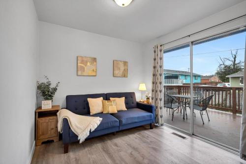 a living room with a blue couch and a balcony at Rainier Entire Upper Floor - Walk to Metro in Seattle