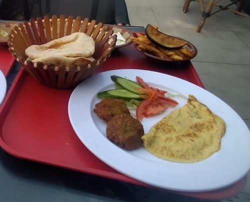 a red tray with a plate of food on it at Victoria Hostel for men only in Alexandria