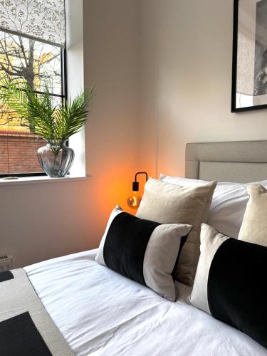 a bed with black and white pillows and a window at Chester's - Central Chester Stays - 2 Cuppin Street - 2 Minute Walk From Shops in Chester
