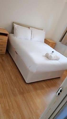 a large white bed with white sheets and pillows at Norwich Home in Norwich