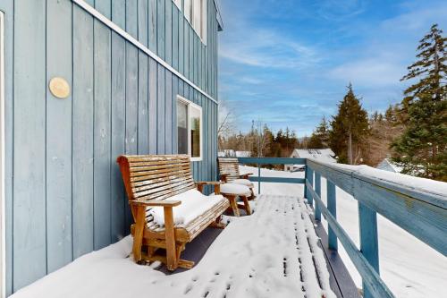 a porch with snowcovered chairs on a blue building at West Dover Getaway in West Dover