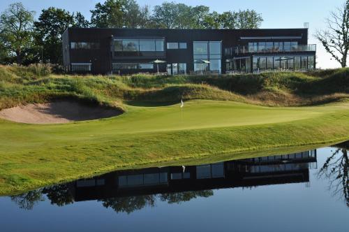 a house on the hill with a reflection in the water at Sand Golf Club in Bankeryd