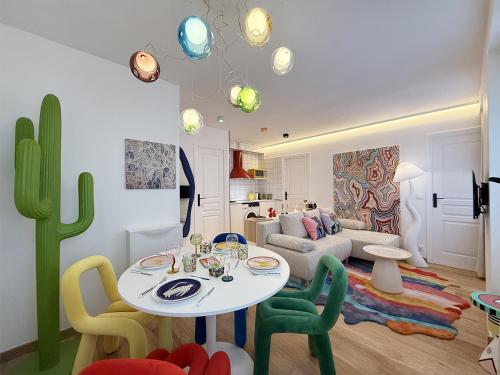 un salon avec une table, des chaises et un canapé dans l'établissement Pop Art & Vibrant Parisian Flat, à Paris