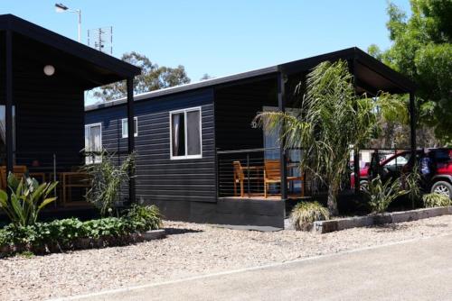 una pequeña casa negra con porche en Stawell Grampians Gate C & C Park, en Stawell