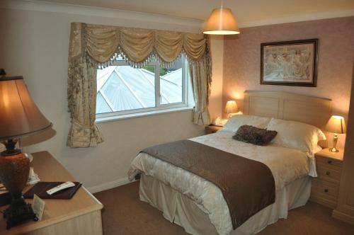 A bed or beds in a room at Ardmore House Hotel 