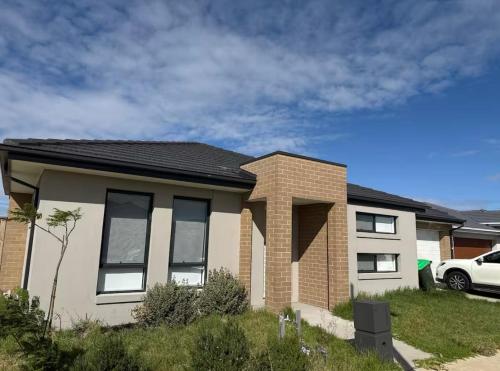 a brick house with a car parked in front of it at Home in Wyndham Vale (Manor Lakes) Melbourne in Wyndham Vale