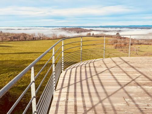 a wooden boardwalk leading to a field with fog in the background at S'évader vers l'horizon 6pers, calme, wifi in Chalvignac