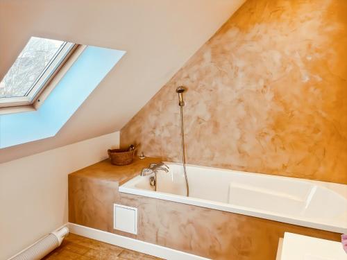 a bathroom with a bath tub and a window at S'évader vers l'horizon 6pers, calme, wifi in Chalvignac