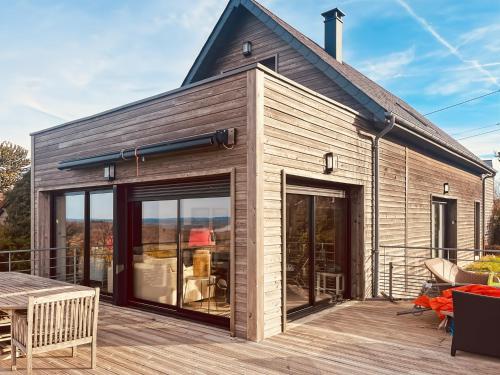 a house with sliding glass doors on a deck at S'évader vers l'horizon 6pers, calme, wifi in Chalvignac