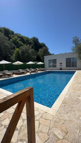 une piscine avec chaises et parasols à côté d'un bâtiment dans l'établissement Eman Villas, à Ulcinj