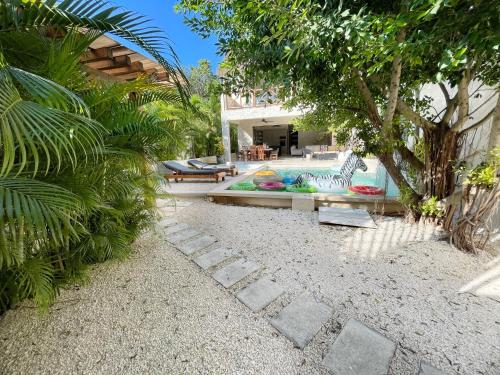 Luxury House Tomanoa - 10pers - 4rooms - Pool - HotJacuzzi - Speed Wifi -waterfall في تولوم: حديقة خلفية مع حمام سباحة ومنزل