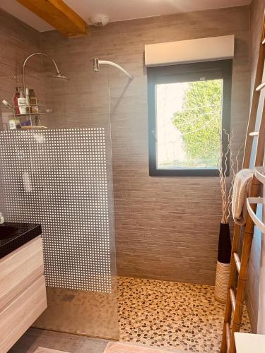 a bathroom with a shower with a glass door at S'évader vers l'horizon 6pers, calme, wifi in Chalvignac