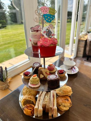 a three tiered tray with different types of pastries and desserts at Broom Hall Country Hotel in Saham Toney