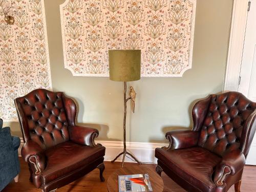 two leather chairs and a lamp in a living room at Broom Hall Country Hotel in Saham Toney