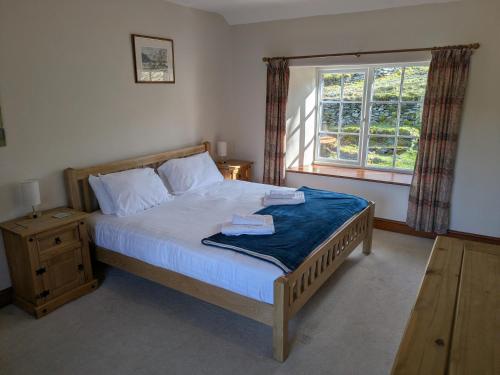 un dormitorio con una cama y una ventana en Wythebank, en Ambleside