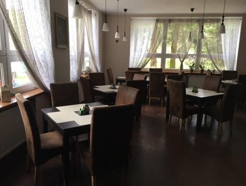 a dining room with tables and chairs and windows at Lávka 222 in Chocerady