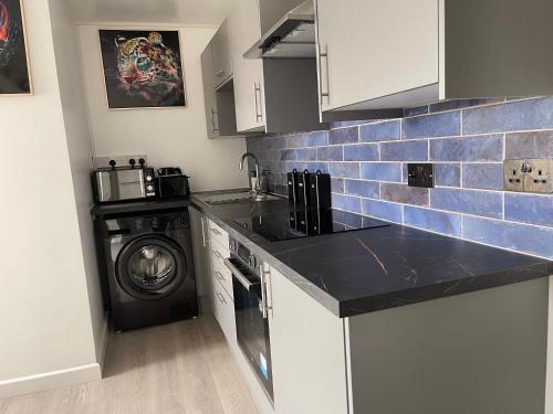 a kitchen with a washer and a washing machine at welcome rooms 47A in Swindon