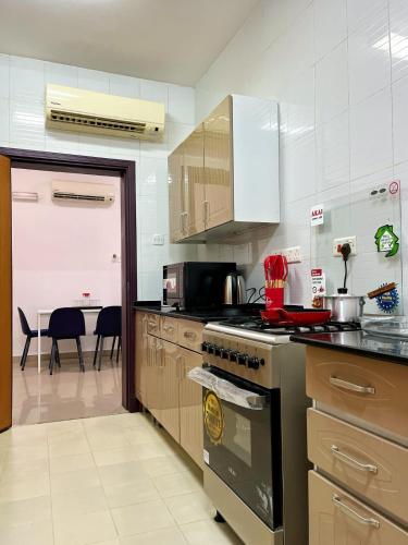 una cocina con estufa horno superior al lado de una mesa en درة الغبره, en Mascate