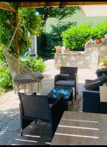 a patio with chairs and tables and a swing at Schöne Gartenwohnung in Salzburg