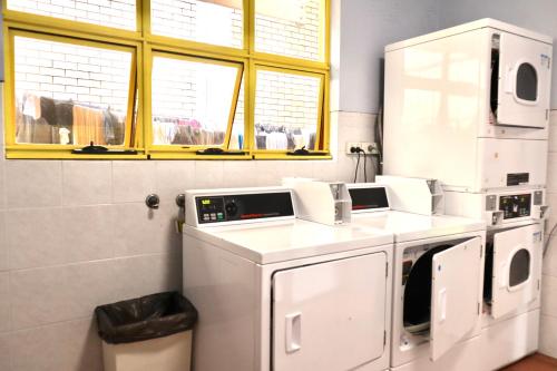 a laundry room with a washer and dryer at City Backpackers HQ in Brisbane