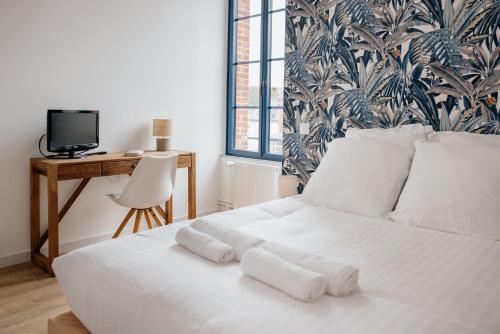 - une chambre dotée d'un lit blanc avec trois oreillers dans l'établissement L'Atelier du Pont, à Guichen