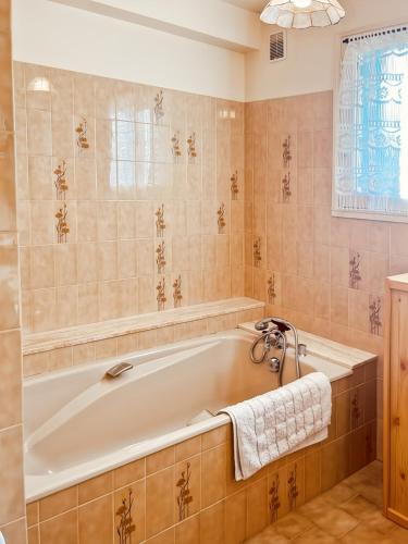 La salle de bains est pourvue d'une baignoire et d'une fenêtre. dans l'établissement Le gîte de Jeannette, 8pers, à Lacapelle-Viescamp