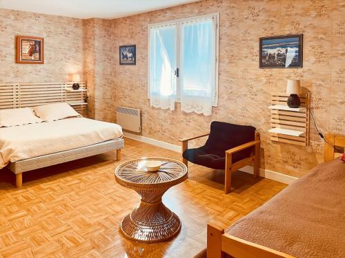 une chambre avec un lit, une chaise et une table dans l'établissement Le gîte de Jeannette, 8pers, à Lacapelle-Viescamp