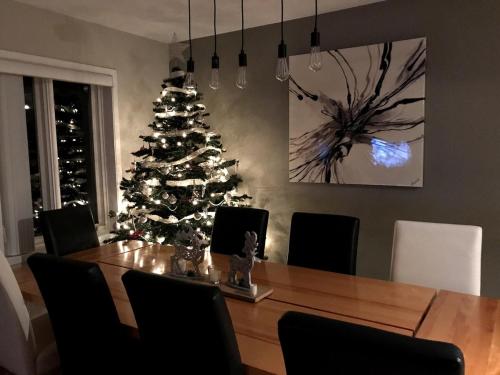 a dining room with a table and a christmas tree at OBerge in Saint-Raymond