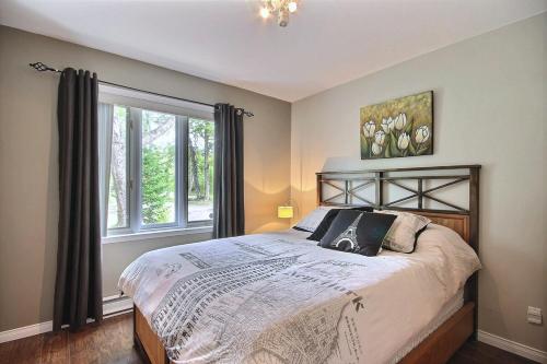a bedroom with a large bed and a window at OBerge in Saint-Raymond