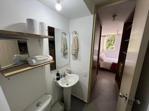Un baño pequeño con lavabo e inodoro. en Apartamento Portanova, vista al bosque, en Piedecuesta
