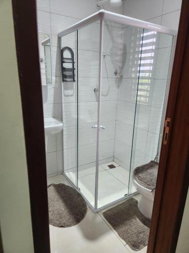 a glass shower in a bathroom with a toilet at Casa Aconchegante em Condomínio Country in Conde
