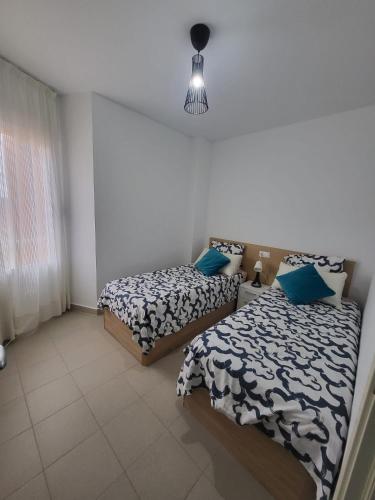a bedroom with two beds and a window at El Soleado El Rincon in Campoamor
