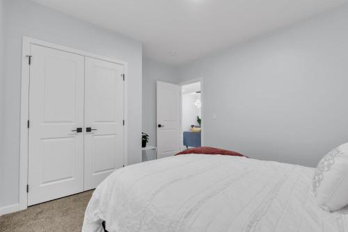 a white bedroom with a bed and white cabinets at You will love this 2BR Guest Suite in SE Calgary in Calgary