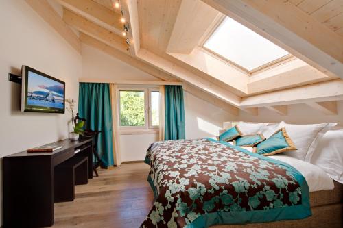 a bedroom with a large bed and a skylight at Alex Lodge Private Luxury Apartments in Zermatt