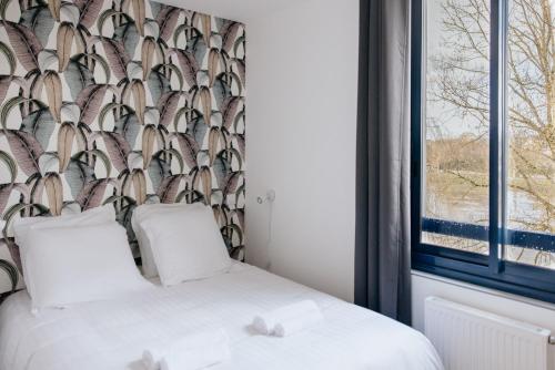 a bedroom with two beds and a window at La Suite du Moulin in Guichen