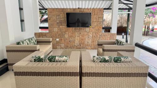 a lobby with couches and a television on a wall at Quinta mi Antojo in Acacías