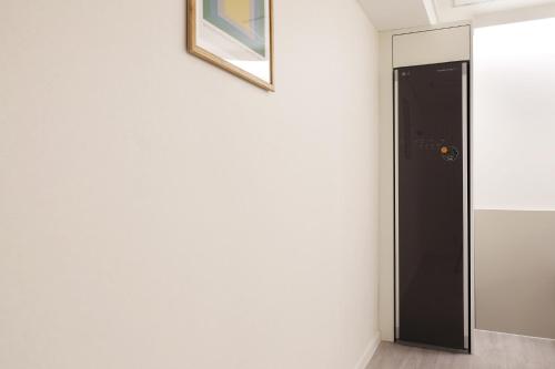 a hallway with a black door and a picture on the wall at Hotel No 25 Gimhae cityhall in Gimhae