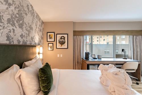 a bedroom with a bed and a desk and a kitchen at Park Town Hotel in Saskatoon
