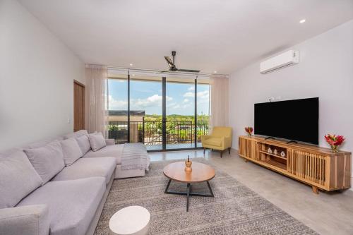 a living room with a couch and a flat screen tv at Villa Maravilla Estates, Tamarindo Beach, Prime Location, Family & Friends in Tamarindo
