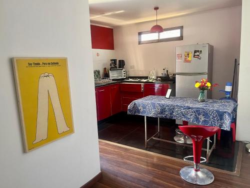 圣地亚哥Hostel Tu Espacio RE - Habitaciones cerca del Aeropuerto的带桌子和冰箱的小厨房