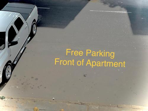 a white car parked in a parking lot with the words free parking front of appointment at White Apartment in Aqaba