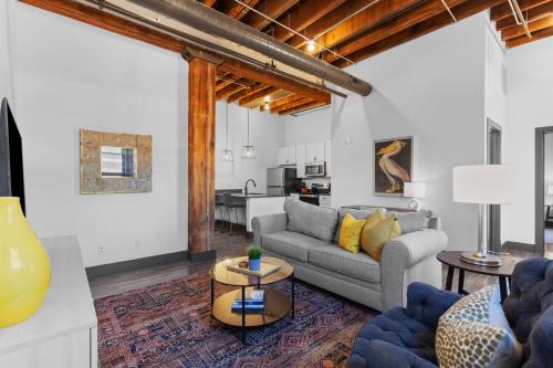 a living room with a couch and a table at Brick & Bed Riverfront Lofts, PC 102 in Saint Louis