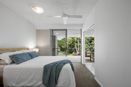 une chambre avec un grand lit et un balcon dans l'établissement Pool View 3-Bedroom Oasis in Drift Resort, à Casuarina