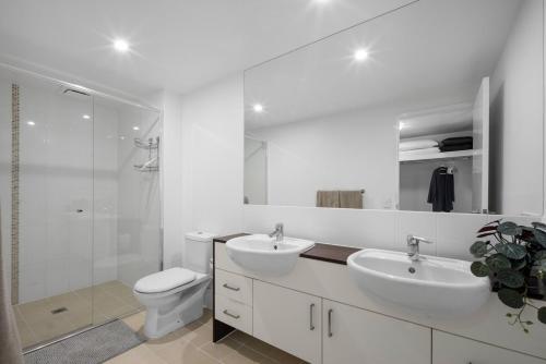 La salle de bains blanche est pourvue de 2 lavabos et de toilettes. dans l'établissement Pool View 3-Bedroom Oasis in Drift Resort, à Casuarina