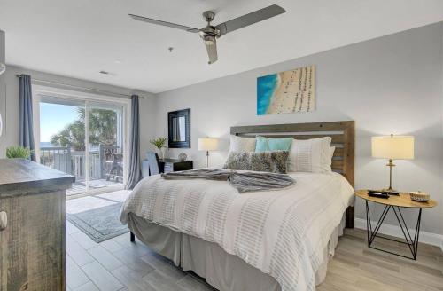 a bedroom with a bed with a ceiling fan at Beachfront 3BDR Condo with Pool & Deck Ocean Views Ocean Blvd #102 by AvantStay in Isle of Palms