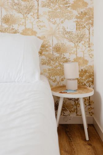a bedroom with a bed and a table with a lamp at Le Rivage in Guichen